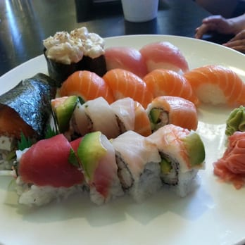 Sushi Cortaro - Normal scallop, yellowtail in back, salmon in the middle, philly handroll to the left, and another rainbow roll in front. - Sushi Bars Near Me - Tucson, Arizona
