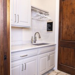 Laundry room with custom flooring and utility sink