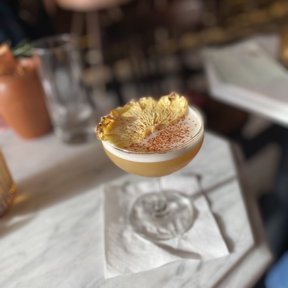 a cocktail with a pineapple garnish a cocktail with a pineapple garnish