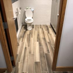 Bannon Tile - 6x36" porcelain wood-look plank flooring. 3x6 white subway walls w/ glass mosaic.