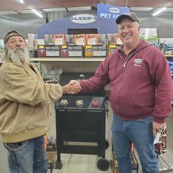 Warren with customer who won a grill in a store giveaway.
