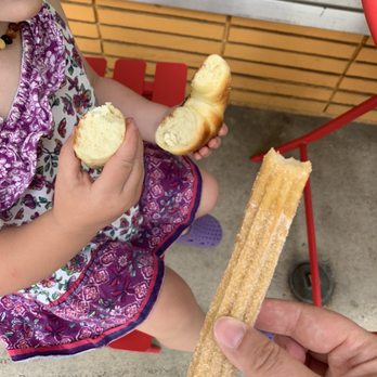 Jakimelis Bakery - a little girl eating a piece of bread - Bakeries Near Me - Brigham City, Utah Jakimelis Bakery - a little girl eating a piece of bread - Bakeries Near Me - Brigham City, Utah