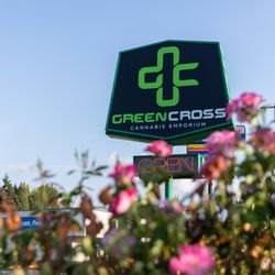 Green Cross Cannabis Emporium - Green Cross sign with pretty flowers.
