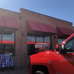 a red truck parked in front of a store a red truck parked in front of a store