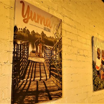 Yuma Visitors Bureau - The inside of the Visitor Center showcases the last few years of their Cover of their Visitor's Guide. - Travel Services Near Me - Yuma, Arizona