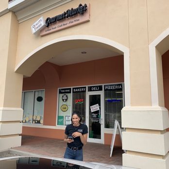 Quality Foods Market - a woman standing in front of a store - Wine Bars Near Me - Lutz, Florida Quality Foods Market - a woman standing in front of a store - Wine Bars Near Me - Lutz, Florida
