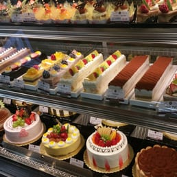 a variety of cakes in a display case