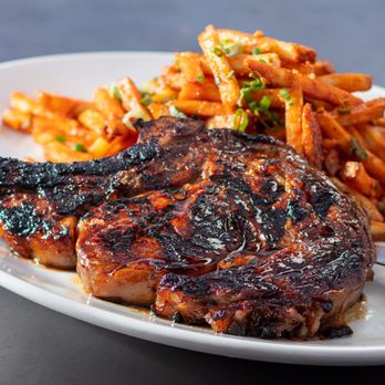 Yard House - Our 20 oz bone-in ribeye, with a sweet soy ginger marinade and chili garlic fries with green onions, parmesan and crispy garlic. - Bars Near Me - Temecula, California Yard House - Our 20 oz bone-in ribeye, with a sweet soy ginger marinade and chili garlic fries with green onions, parmesan and crispy garlic. - Bars Near Me - Temecula, California