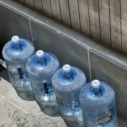 Empty bottles gathering and waiting to be picked up in front of our home.