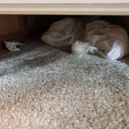balled up clothing and trash under bed