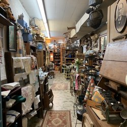 Ole Grapevine Antiques - One long aisle... full of embroidered items and candlewicking... rugs... and rustic wood pieces.