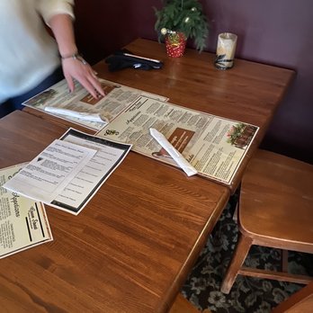 Green Street Tavern - a person sitting at a table with menus - Barbeque Near Me - Galena, Illinois Green Street Tavern - a person sitting at a table with menus - Barbeque Near Me - Galena, Illinois