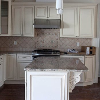 Ora Construction - a kitchen with white cabinets and granite countertops - General Contractors Near Me - Syosset, New York