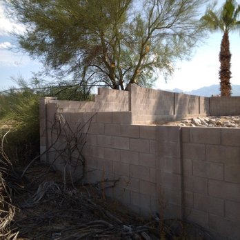 D&J Landscape Maintenance - a brick wall with a tree in the background - Landscaping Near Me