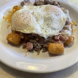 The Country Restaurant & Lounge - Breakfast tots with ham, sausage, cheddar cheese, country gravy and two over easy eggs