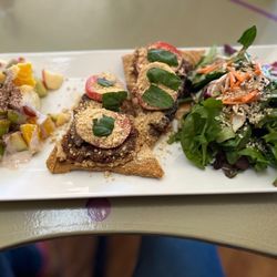 Dinner size pizza, which includes a chef prepared fruit salad and a veggie salad.