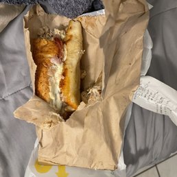 a person holding a sandwich in a paper bag a person holding a sandwich in a paper bag