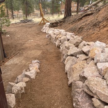 Mountain High Creations - a stone retaining wall in the foreground - Landscaping Near Me