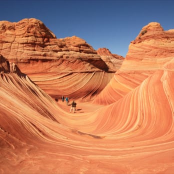 The Wave at Coyote Buttes - Iron deposits twist and blend to create a rainbow of orange, pink, and red swirls. - Hiking Near Me