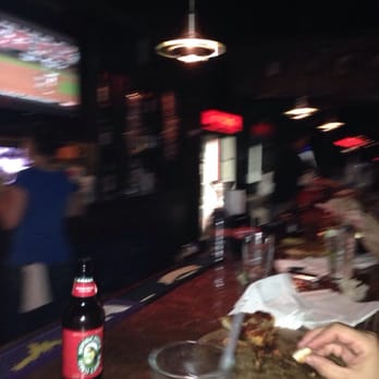 Straycat - a person sitting at a bar with a bottle of soda - Bars Near Me - Shreveport, Louisiana