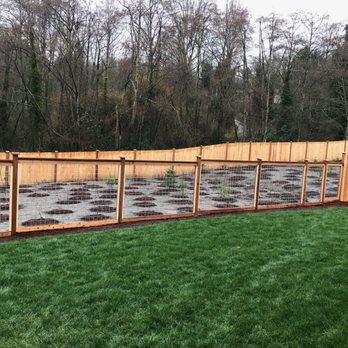 Premium Wood - 5 foot welded hog fence replacing cheaper log fence separating backyard from wet lands. - Fences & Gates Near Me - Bothell, Washington Premium Wood - 5 foot welded hog fence replacing cheaper log fence separating backyard from wet lands. - Fences & Gates Near Me - Bothell, Washington
