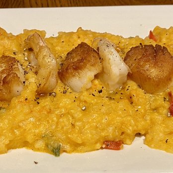 Marblehead Chowder House - Pan Seared Shrimp & Scallops with Lobster Risotto - Shrimp and scallops are served on a bed of yellow lobster risotto, garnished with a lemon wedge, in a seafood restaurant setting. - Seafood Near Me - Easton, Pennsylvania