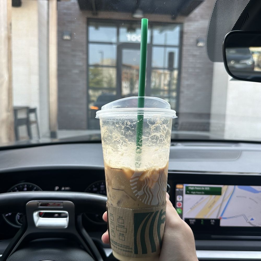 a hand holding a cup of iced coffee a hand holding a cup of iced coffee