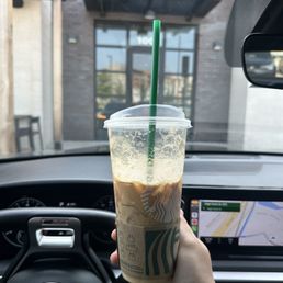 a hand holding a cup of iced coffee