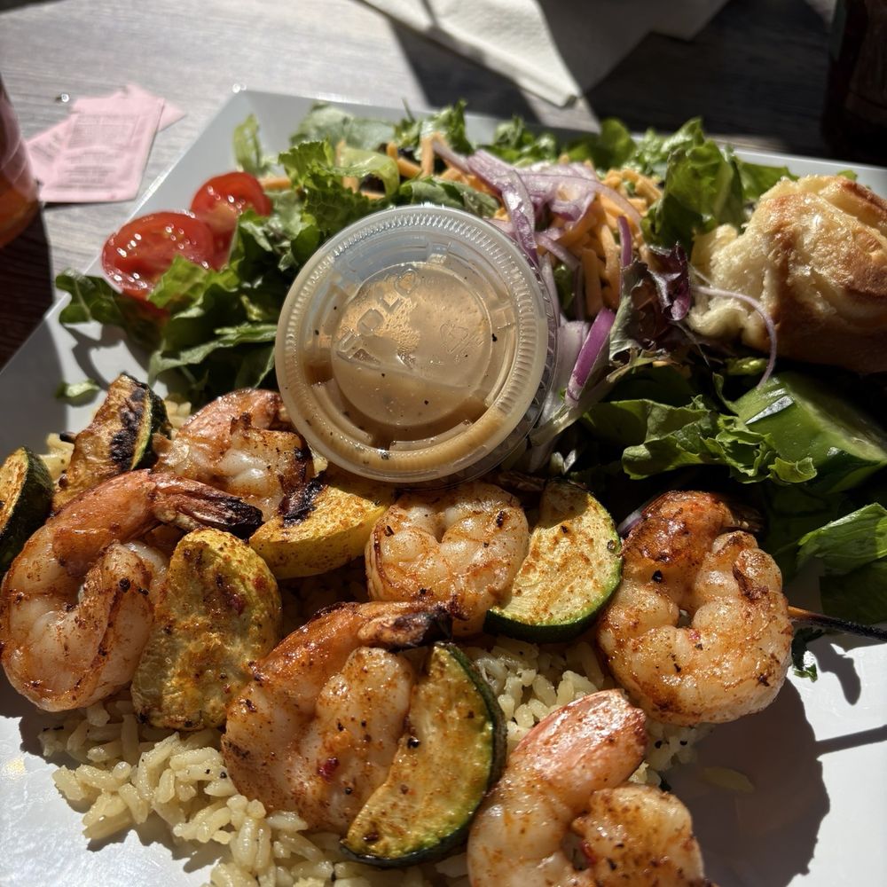 Grilled shrimp and veggies over seasoned rice, with side salad and an orange roll. Grilled shrimp and veggies over seasoned rice, with side salad and an orange roll.