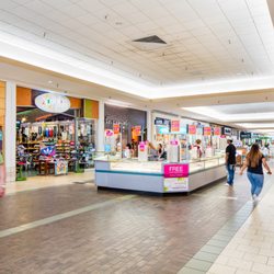 NorthPark Mall - Shoppers walk through a NorthPark Mall corridor past Journeys and a jewelry kiosk.