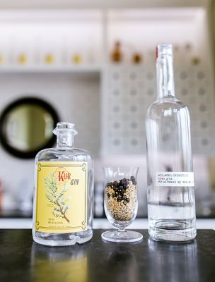 Photo of Wildwood Spirits - Bothell, WA, US. a bottle of wildflower gin and a glass filled with wildflower seeds