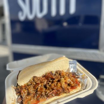 Big South - a hand holding a hot dog - Soul Food Near Me Big South - a hand holding a hot dog - Soul Food Near Me