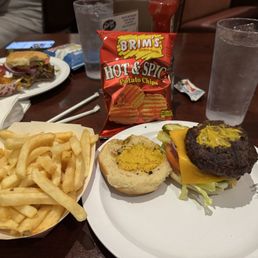 Cheeseburger with fries and a bag of chips. Cheeseburger with fries and a bag of chips.