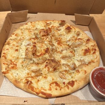 Pizza 101 - Garlic cheese stix - Cheese pizza topped with chicken and garlic, presented in a takeout box with a cup of marinara sauce on the side. - Pizza Near Me - Keystone, Colorado