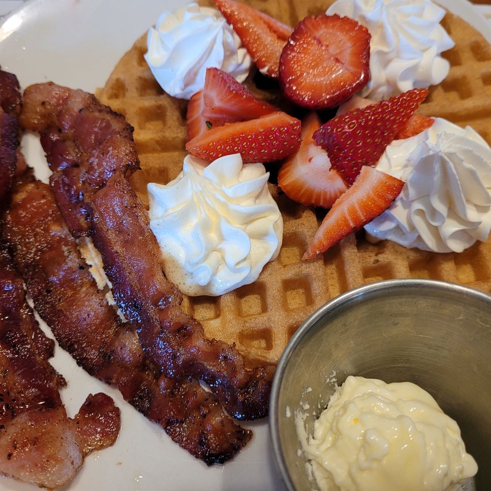 a waffle with bacon, strawberries, and whipped cream a waffle with bacon, strawberries, and whipped cream
