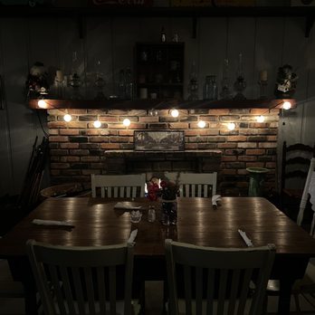 Wells Cargo Cafe - a table and chairs in a dimly lit room - Cafes Near Me - Stone Mountain, Georgia