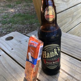 a bottle of hank's beer and a bag of chips on a picnic table a bottle of hank's beer and a bag of chips on a picnic table