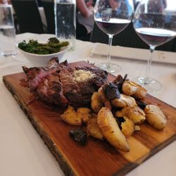 Lookout Lounge - The carnivore's board, a perfect share. | ribeye (20oz, medium) with crisp tender fingerlings and roasted broccolini. Paired with bourbon.