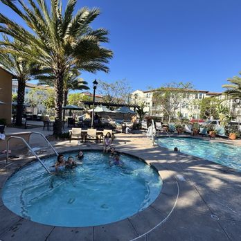 Enclave Otay Ranch - Pool area, gym in the background and grills to the right area and behind on the other side of the pool - Apartments Near Me - Chula Vista, California