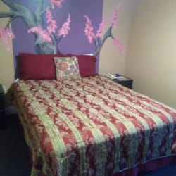 Queen size bed with painted Asian inspired mural on the wall.