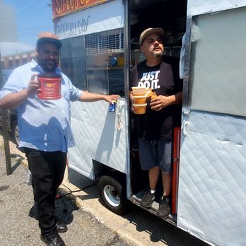 Roostercall - two men standing outside of a food truck - Food Trucks Near Me