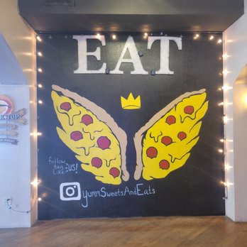Yumm! Sweets & Eats - a wall with a sign that says eat - Pizza Near Me - Brenham, Texas