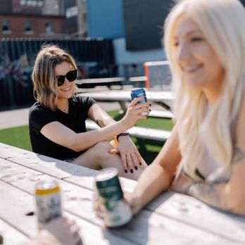 The Docks Container Lounge - two women sitting at a picnic table - Beer Bar Near Me - Saint John, New Brunswick
