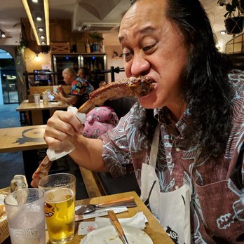 Aloha Steak House - Fred Flinstone style attacking the bone... - Steakhouses Near Me - Honolulu, Hawaii