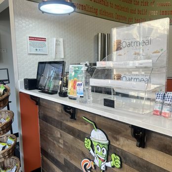 Smoothie Rx - the counter of a smoothie shop - Smoothie RX counter with a smoothie mascot sign, display case, and a tablet for orders, in a health-focused setting. - Juice Bars & Smoothies Near Me - Chicago, Illinois