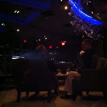 R5 - two people sitting in chairs in a dimly lit room - Lounges Near Me - Niagara Falls, Ontario R5 - two people sitting in chairs in a dimly lit room - Lounges Near Me - Niagara Falls, Ontario