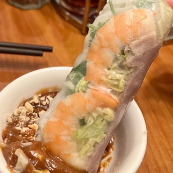 Saigon Noodles - a hand holding a roll of food - Vietnamese Near Me - Madison, Wisconsin