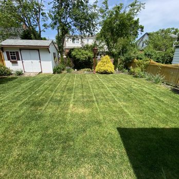 Gonzalez Landscaping - a lawn with a mower in the foreground - Lawn Services Near Me Gonzalez Landscaping - a lawn with a mower in the foreground - Lawn Services Near Me