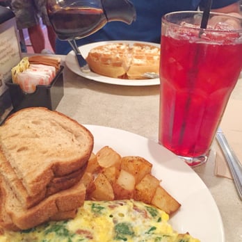 The Paramount - Bacon, blue cheese and spinach omelette with home fries and Crimson Berry tea. Belgian waffle in the background. - Breakfast & Brunch Near Me - Boston, Massachusetts