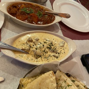 Sizzling Bombay - From top to bottom: goat vindaloo, lamb mazedar, garlic naan, and paneer kulcha. - Indian Near Me - Bel Air, Maryland Sizzling Bombay - From top to bottom: goat vindaloo, lamb mazedar, garlic naan, and paneer kulcha. - Indian Near Me - Bel Air, Maryland